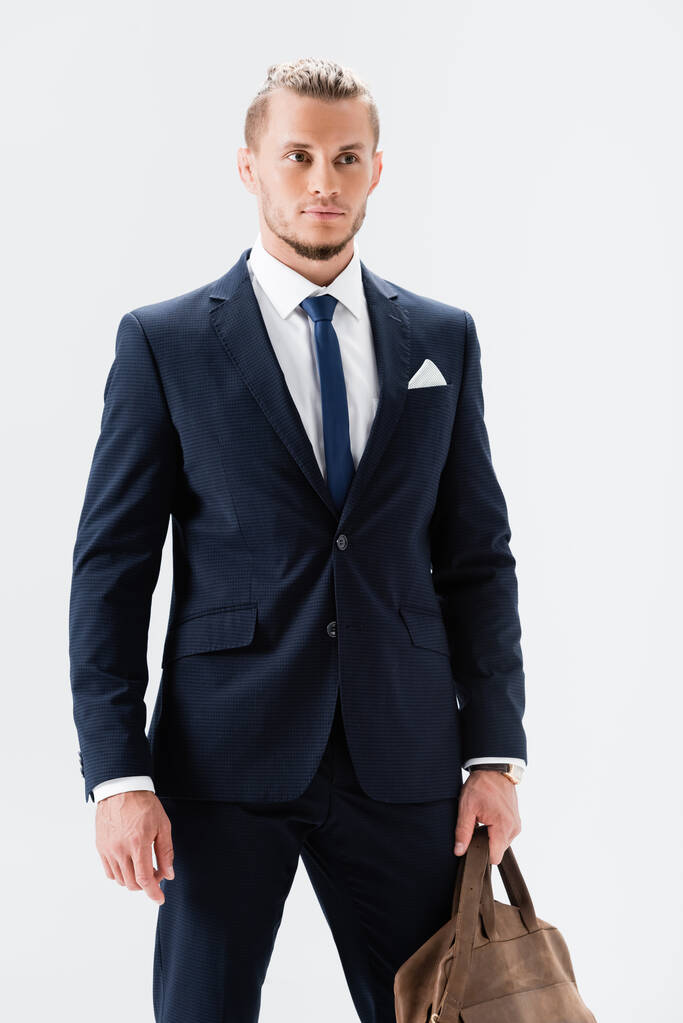 joven hombre de negocios en traje con maleta aislada en blanco - Foto, imagen