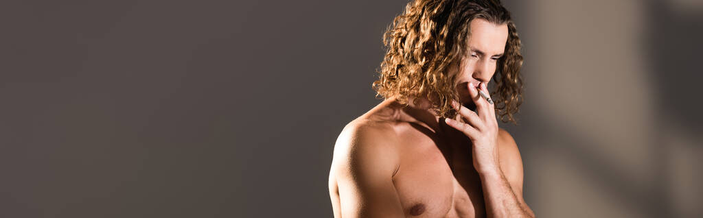 sexy homme torse nu avec des cheveux longs fumant sur fond sombre, bannière - Photo, image