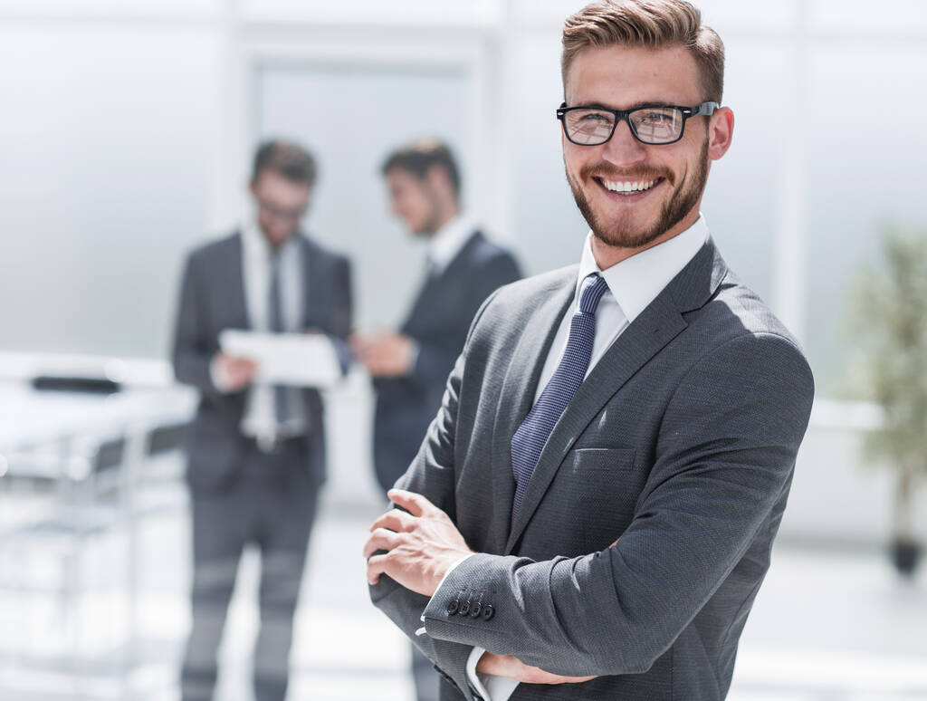 Selbstbewusster Geschäftsmann vor dem Hintergrund eines modernen Büros - Foto, Bild