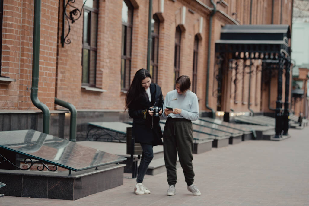 若い女性写真家が彼女と路地を歩いている。旅行者は街を歩く。観光名所都市を見る. - 写真・画像