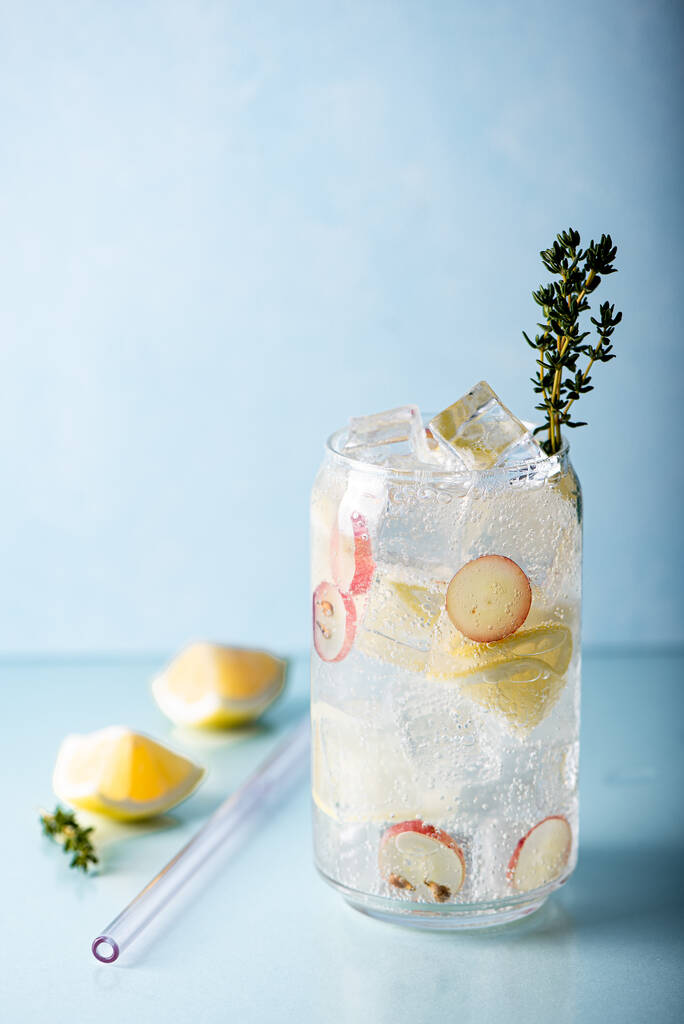 limonada com pedaços de uvas e gelo em um copo alto em um fundo azul - Foto, Imagem