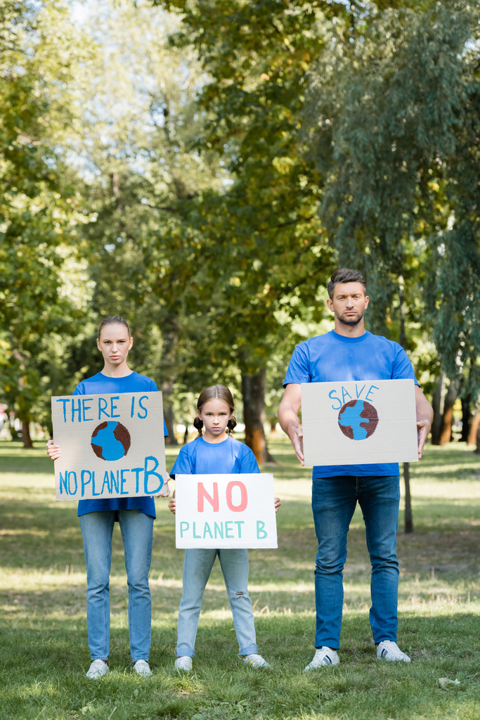 rodzina wolontariuszy posiadających tabliczki z nieistniejącym napisem na planecie b, koncepcja ekologii - Zdjęcie, obraz