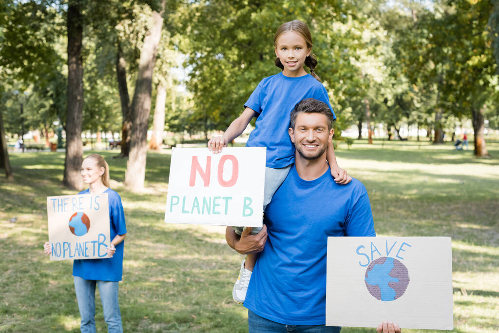 счастливая семья добровольцев, держащих плакаты с нет планеты б надпись и глобус, экологическая концепция - Фото, изображение