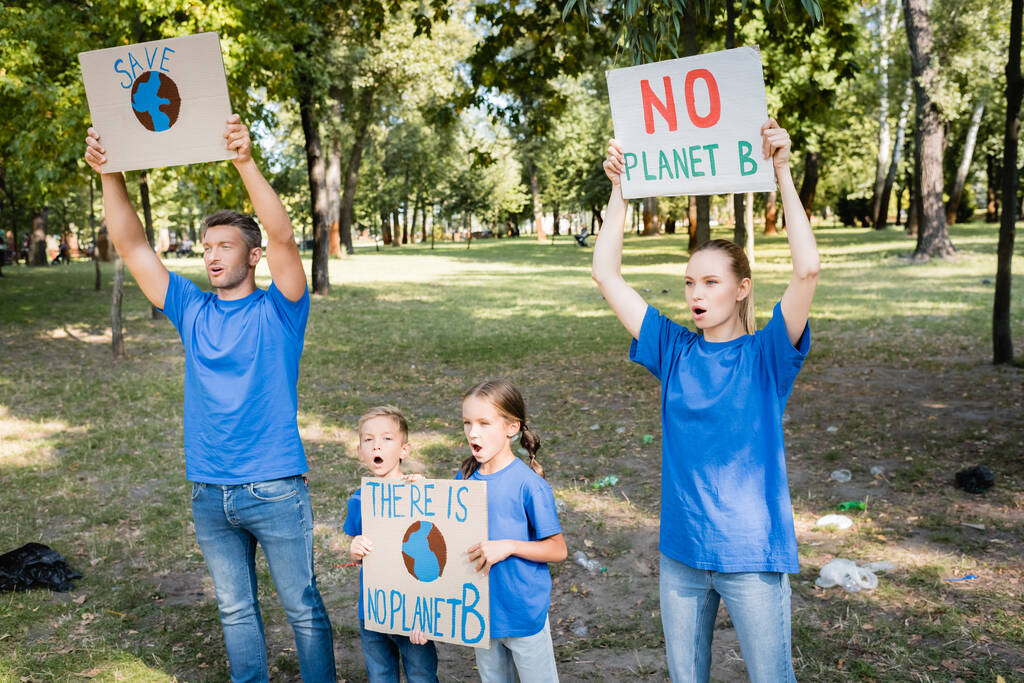 οικογένεια εθελοντών ουρλιάζοντας κρατώντας πλακάτ με την υδρόγειο και χωρίς επιγραφή στον πλανήτη Β, έννοια οικολογία - Φωτογραφία, εικόνα