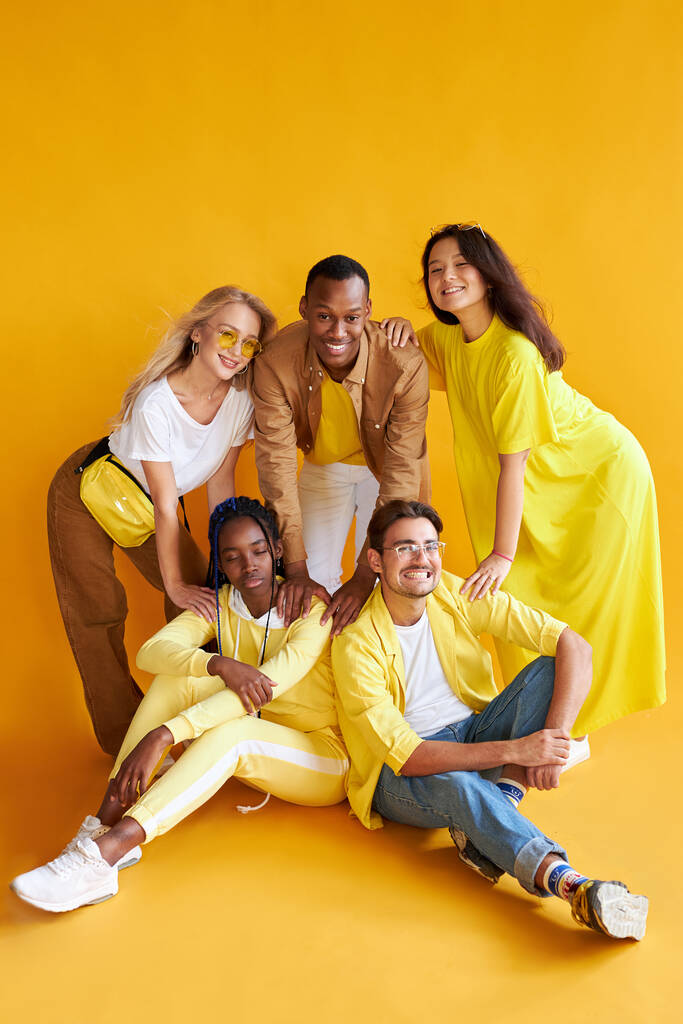 groep van gelukkige jonge mannen en vrouwen geïsoleerd op gele achtergrond - Foto, afbeelding