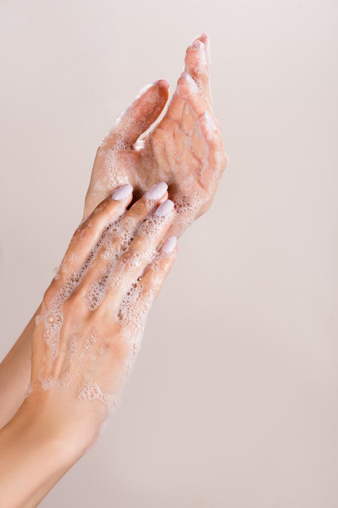 vista recortada de la mujer lavándose las manos aisladas en gris - Foto, imagen