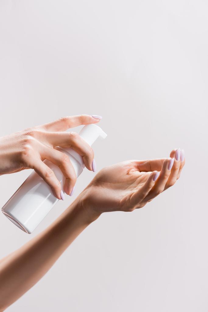 vista ritagliata della donna che applica schiuma detergente isolata sul grigio - Foto, immagini