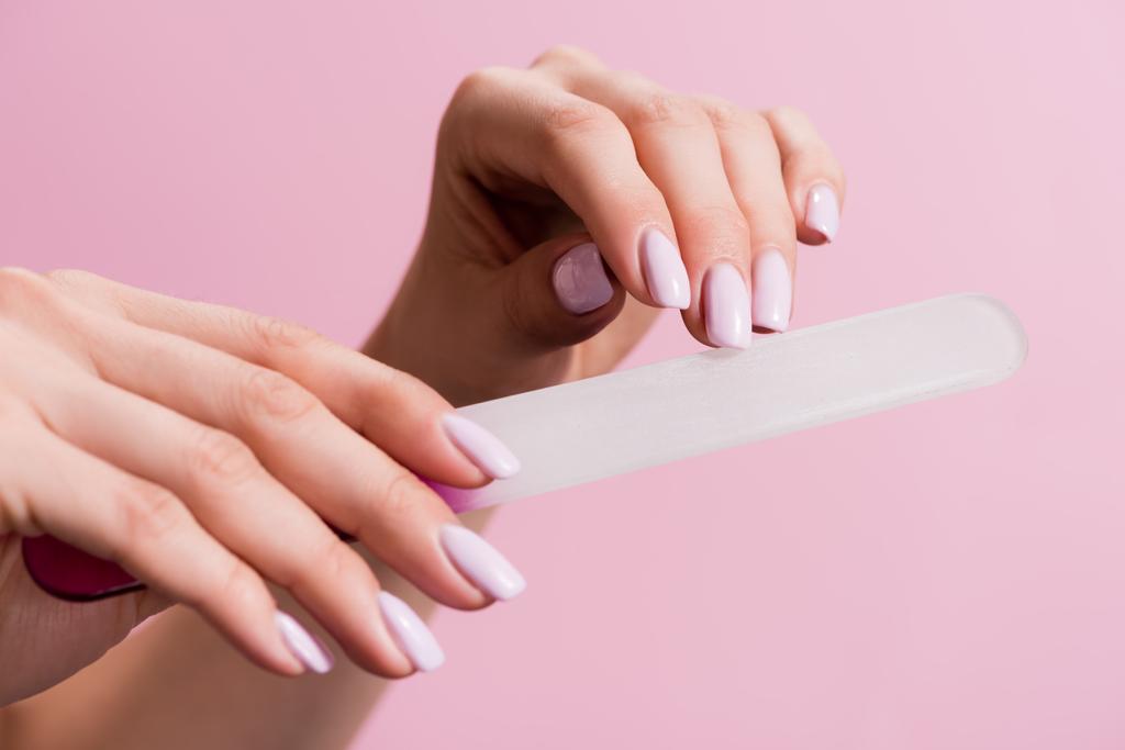 cropped view of woman using nail file isolated on pink - Photo, Image