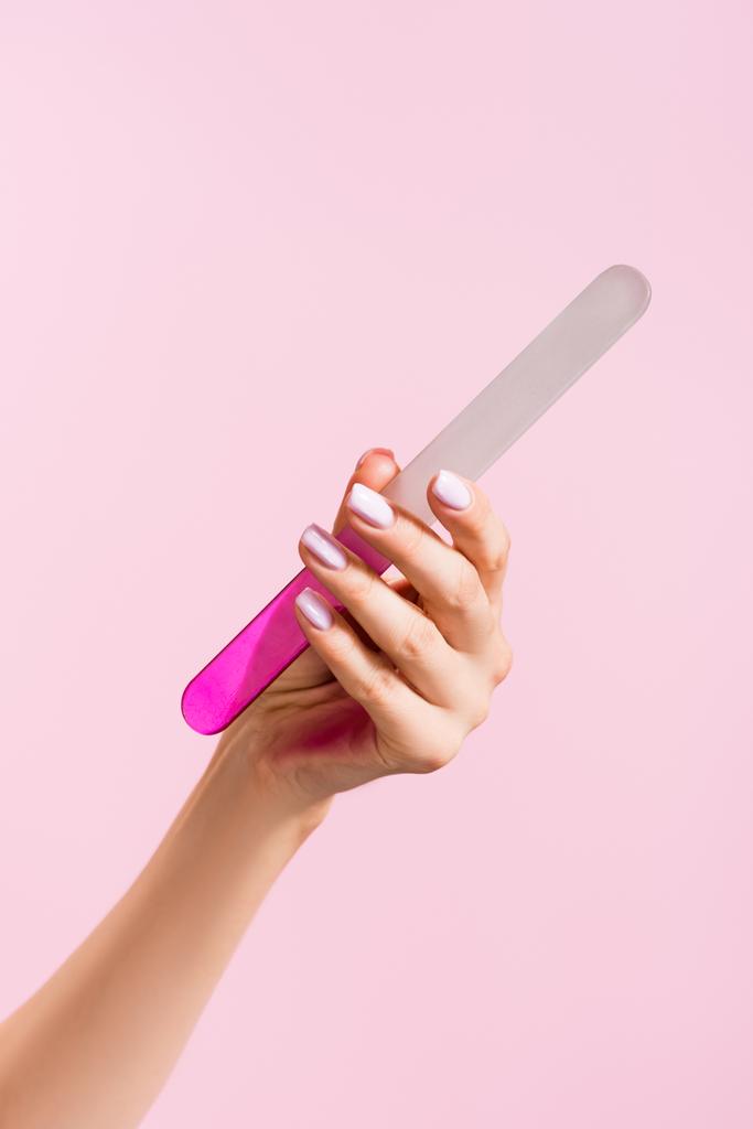 oříznutý pohled ženy držící pilník na nehty izolovaný na růžové - Fotografie, Obrázek