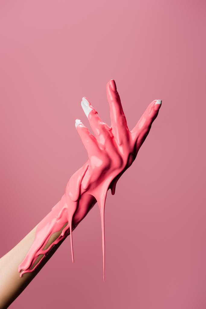 oříznutý pohled na ruku s kapající barvou izolovanou na růžové - Fotografie, Obrázek