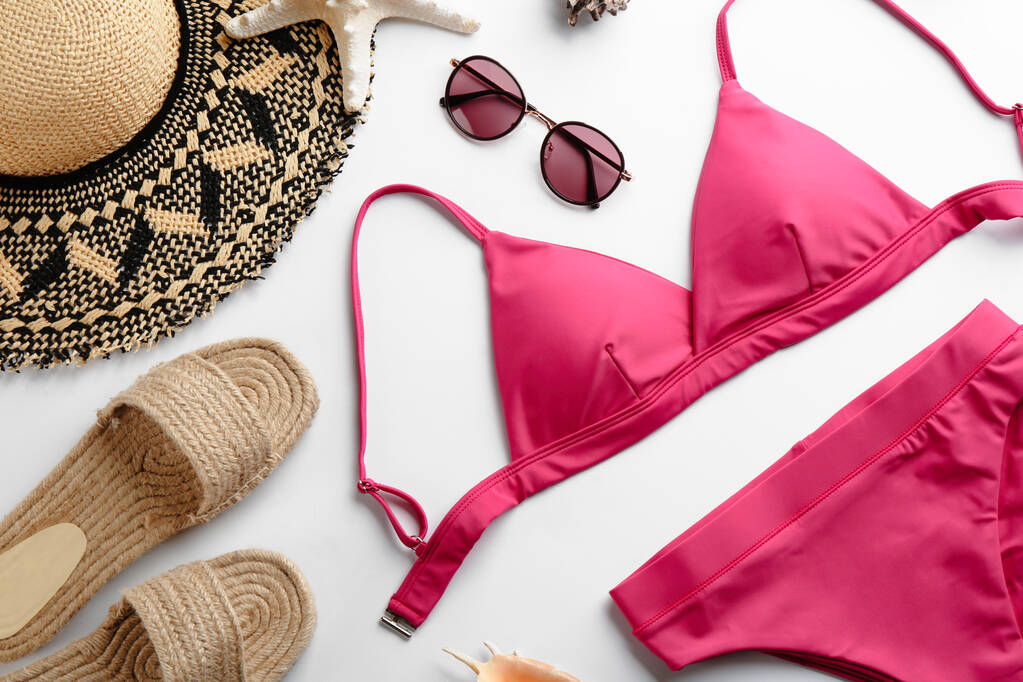 Schöne rosa Bikini und Strand-Accessoires auf weißem Hintergrund, flache Lage - Foto, Bild