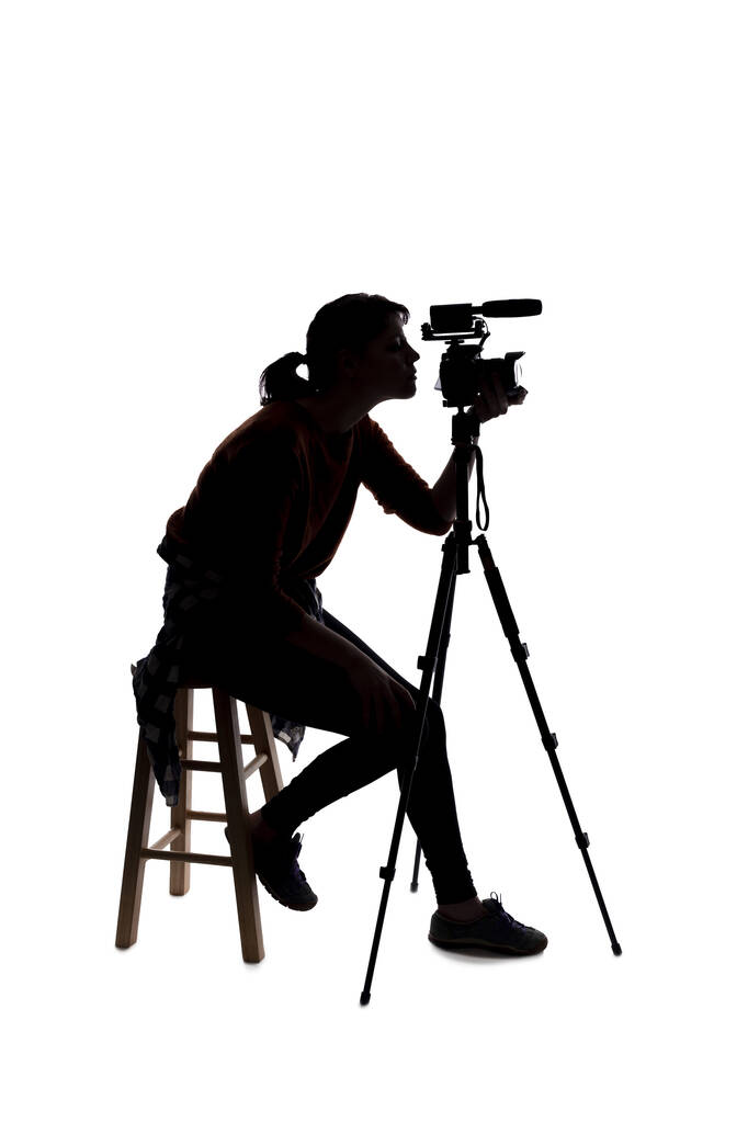 Silhouette di una cineasta indie femminile, creatrice di contenuti online o direttrice di casting con fotocamera e microfono su sfondo bianco - Foto, immagini