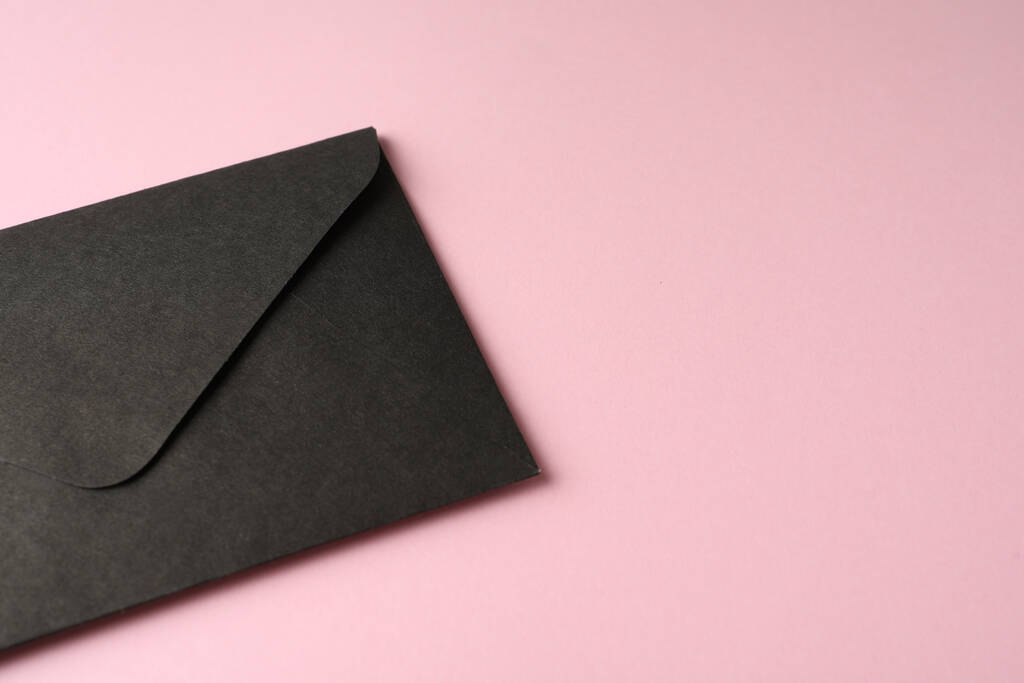 envelope de papel preto sobre fundo rosa, close up. Espaço para texto - Foto, Imagem