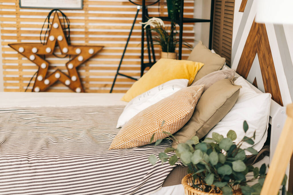 Υπνοδωμάτιο με μεγάλο κρεβάτι και μαξιλάρι σε σκανδιναβικό στυλ, άνεση στο σπίτι. εσωτερική διακόσμηση. - Φωτογραφία, εικόνα