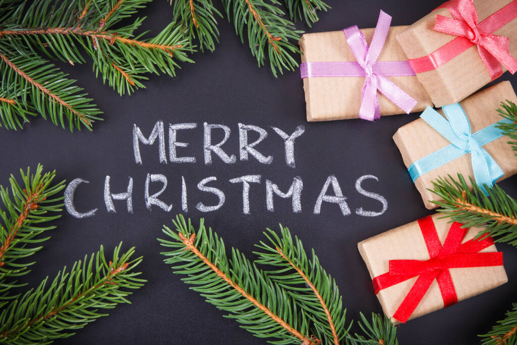 Iscrizione Buon Natale, regali avvolti con nastro e rami di abete rosso verde. Decorazione per il periodo natalizio - Foto, immagini