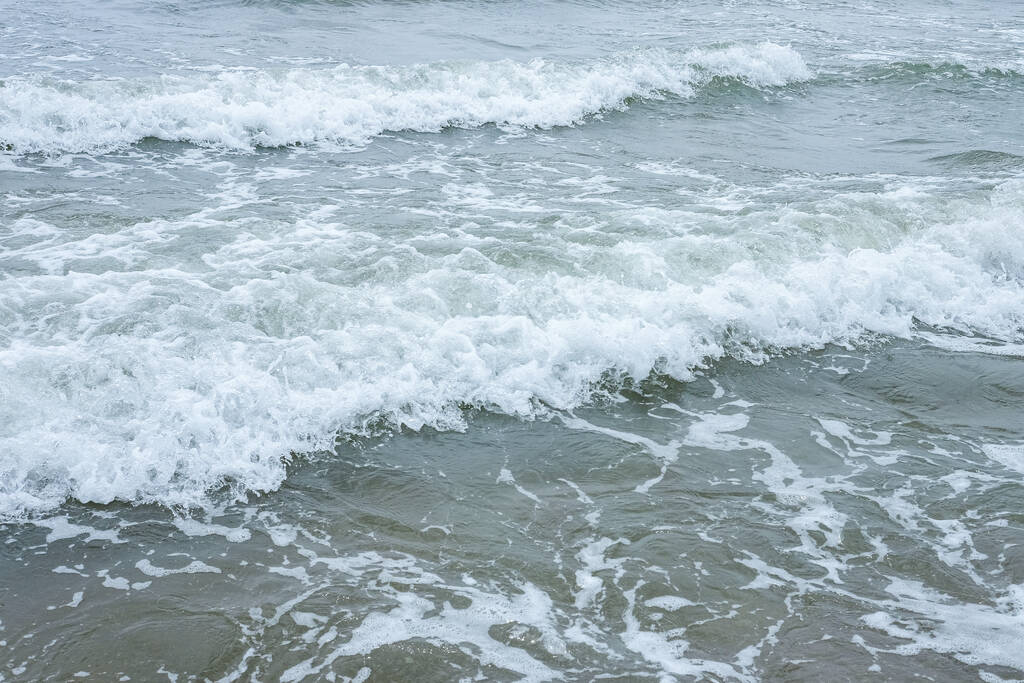 Small waves on the sea coast, foaming waves. - Photo, Image