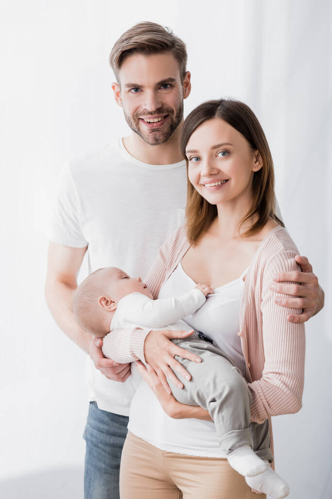 smiling woman holding in arms infant boy near happy husband  - Photo, Image
