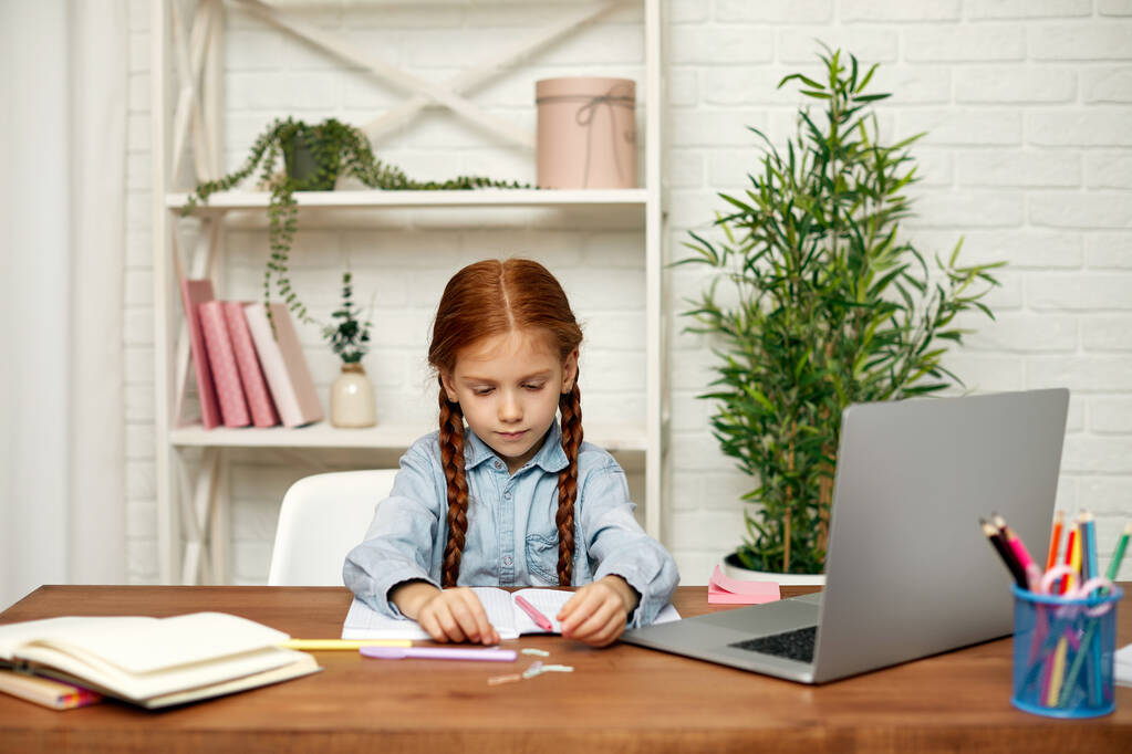pieni lapsi tyttö käyttää kannettavaa tietokonetta opiskeluun verkossa - Valokuva, kuva