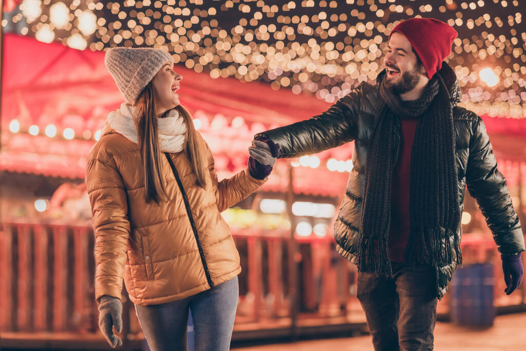 Foto di coppia camminare Natale sera fiera tenere per mano godere di x-mas noel all'aperto illuminazione usura stagione cappotti - Foto, immagini