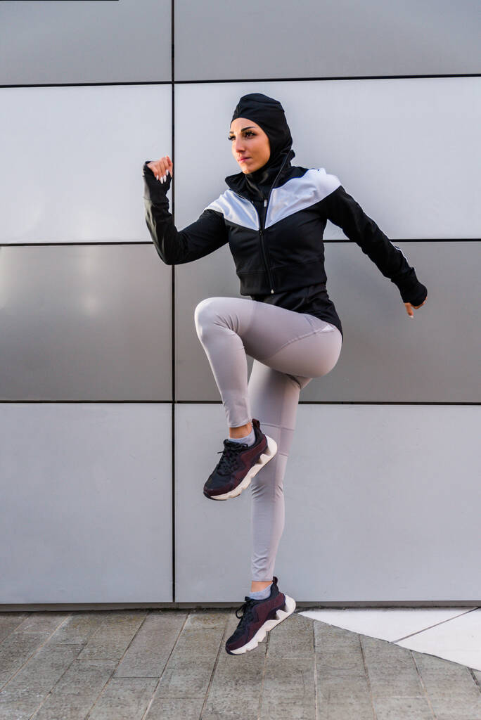 Dışarıda formda vücut eğitimi alan Müslüman sporcu kız - tesettürlü güzel kadın spor egzersizleri yapıyor, sağlık, yaşam tarzı ve işlevsel eğitim hakkında kavramlar yapıyor - Fotoğraf, Görsel