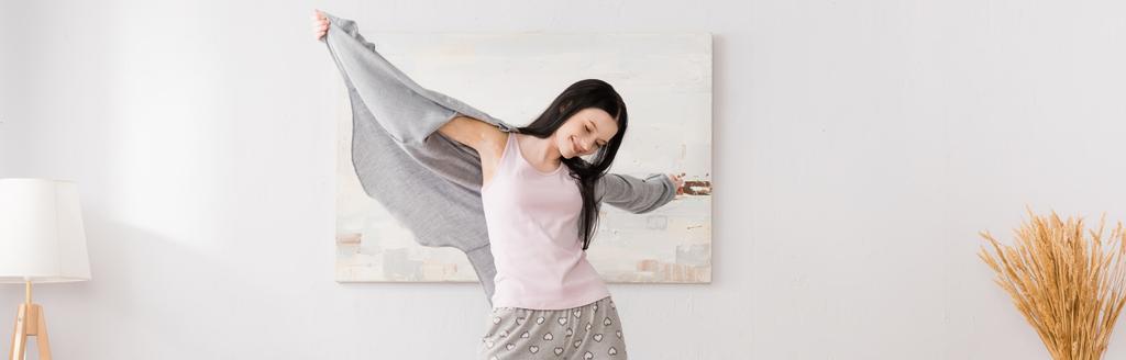 счастливая женщина с витилиго с протянутыми руками в спальне, баннер - Фото, изображение