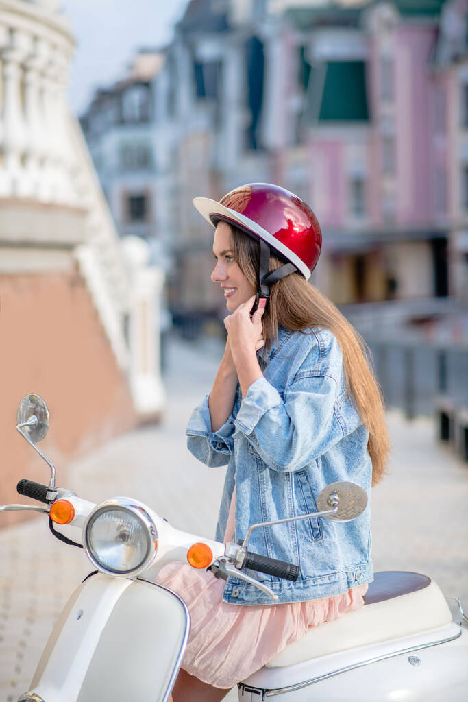 Femme ajustant un casque pour monter un scooter - Photo, image