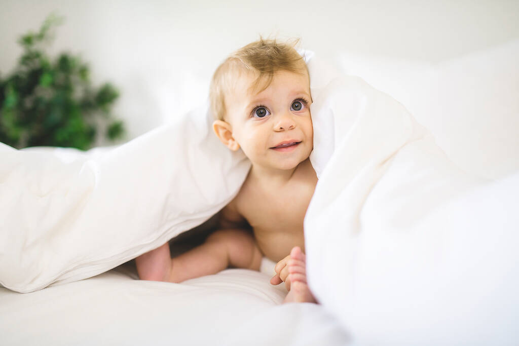 Мила щаслива дівчинка в підгузник на ліжку
 - Фото, зображення