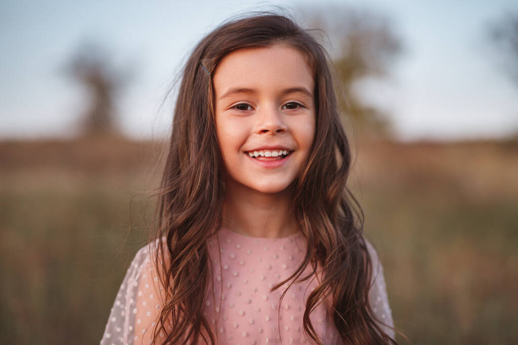 Lächelndes kleines Mädchen steht auf dem Feld - Foto, Bild