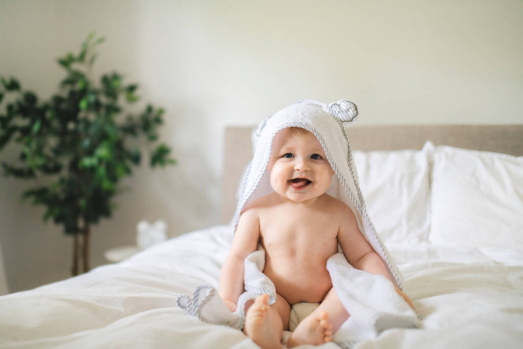 Un bambino carino in biancheria da letto bianca a casa - Foto, immagini