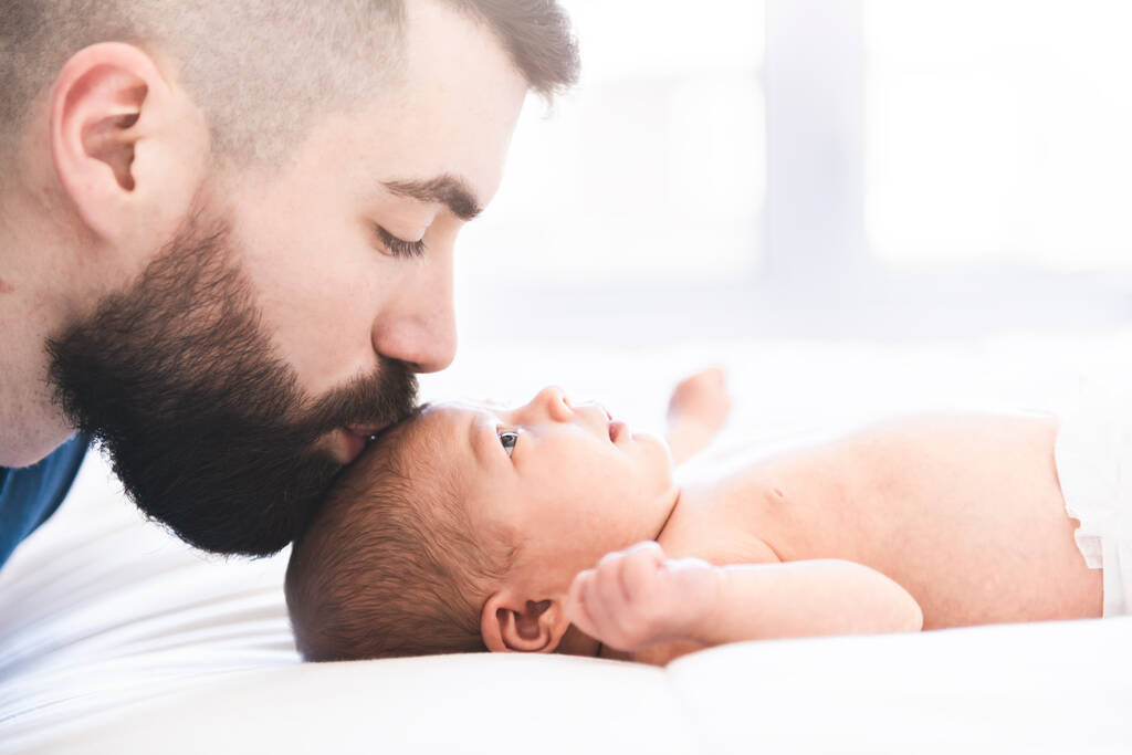padre giaceva sul letto con la sua neonata figlia - Foto, immagini