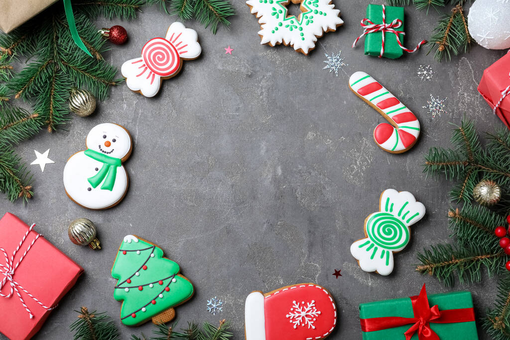 Cadre de biscuits de Noël décorés et coffrets cadeaux sur table grise, plan plat. Espace pour le texte - Photo, image