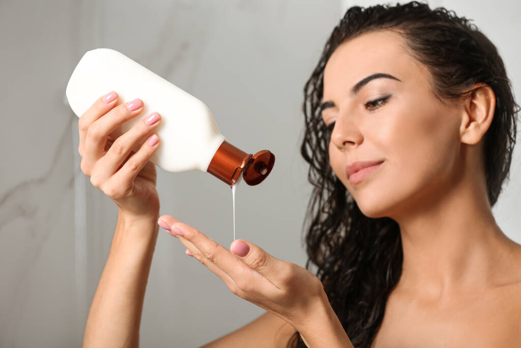 Kaunis nuori nainen pullon shampoo suihkussa kotona - Valokuva, kuva