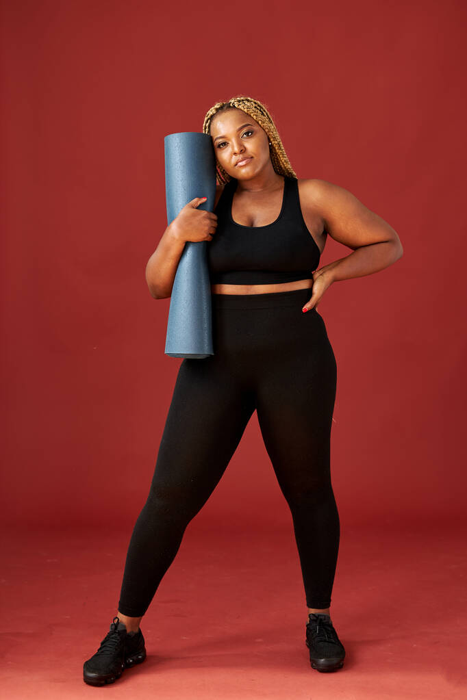 luottavainen musta nainen urheilullinen kulumista menossa tehdä jooga suorittaa matolla - Valokuva, kuva