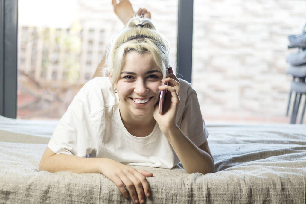 Κοντινό πλάνο πορτρέτο ενός ωραίου χαριτωμένου χαριτωμένου χαριτωμένου χαριτωμένου αξιολάτρευτου εκθαμβωτικού χαρούμενη ξανθιά κυρία ξαπλωμένη στο κρεβάτι λαμβάνοντας b y τηλέφωνο - Φωτογραφία, εικόνα