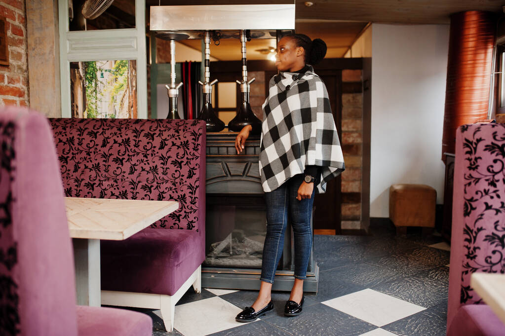 African woman in checkered cape posed at cafe. - Photo, Image