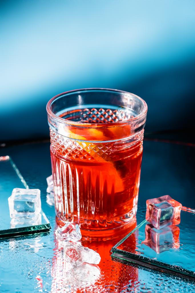 коктейль с виски рядом с кубиками льда на голубом - Фото, изображение