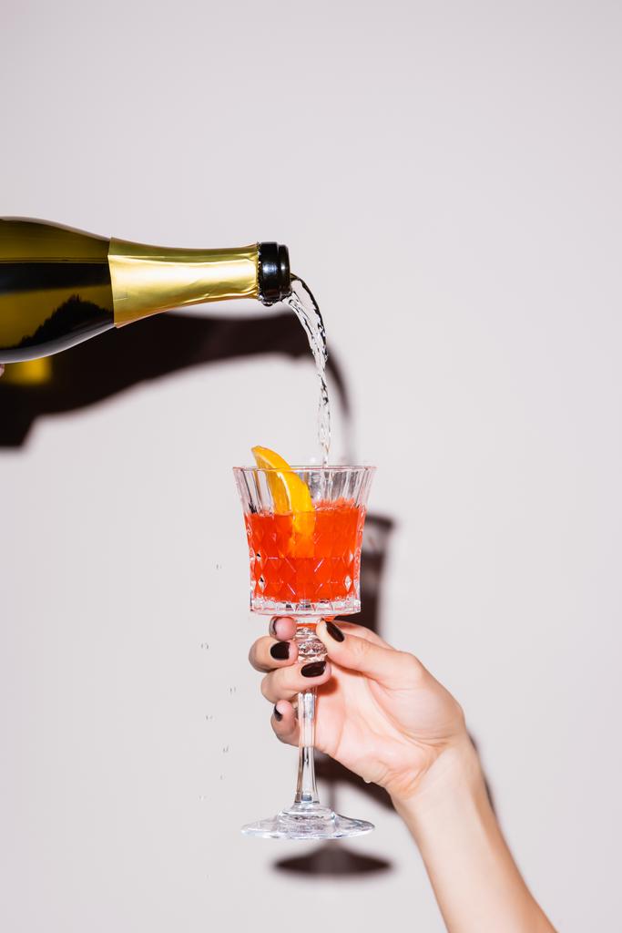 samppanjaa kaatamalla lasiin cocktail pullosta lähellä naista valkoisella - Valokuva, kuva