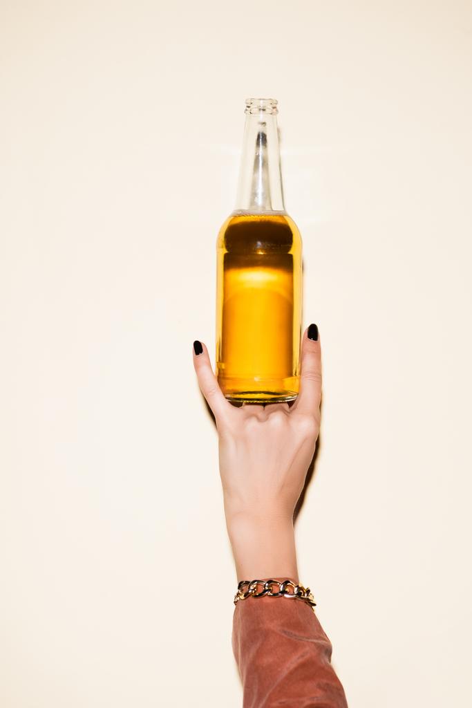 Ausgeschnittene Ansicht einer Frau, die ein Felsschild zeigt, während sie eine Flasche mit Bier auf weiß hält - Foto, Bild