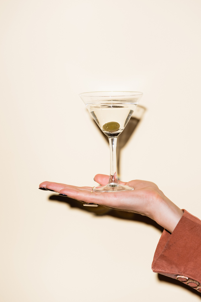 levágott kilátás nő kezében pohár martini zöld olajbogyó kezében fehér - Fotó, kép