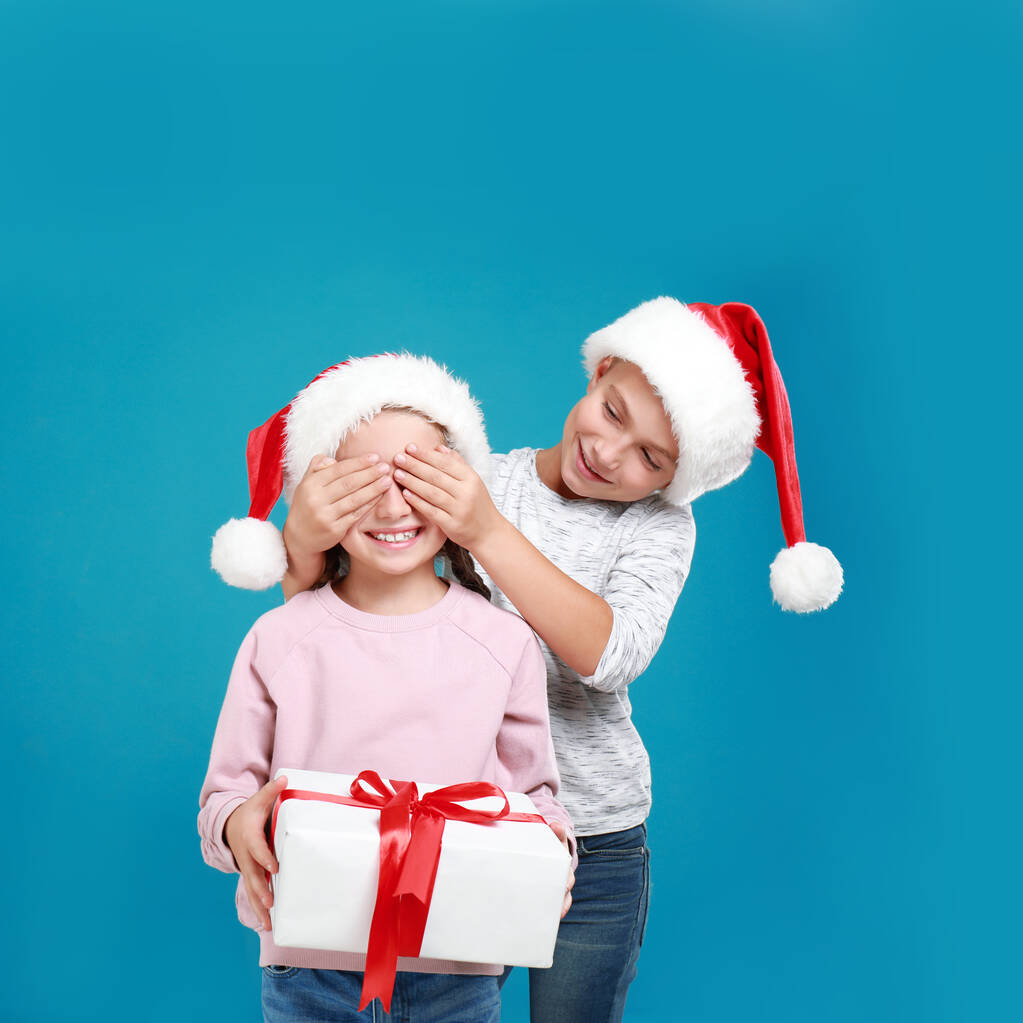 Fiú bemutató karácsonyi ajándék a lány világoskék háttér - Fotó, kép