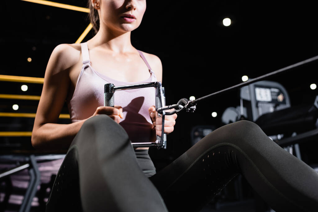 részleges kilátás sportos nő dolgozik ki az evezős gép homályos előtérben - Fotó, kép