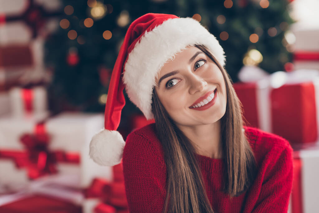 Zdjęcie uroczej dziewczyny błyszczący uśmiech spojrzeć w górę nosić Santa nakrycia głowy czerwony pullover w urządzone x-mas pokój dzienny w pomieszczeniach - Zdjęcie, obraz