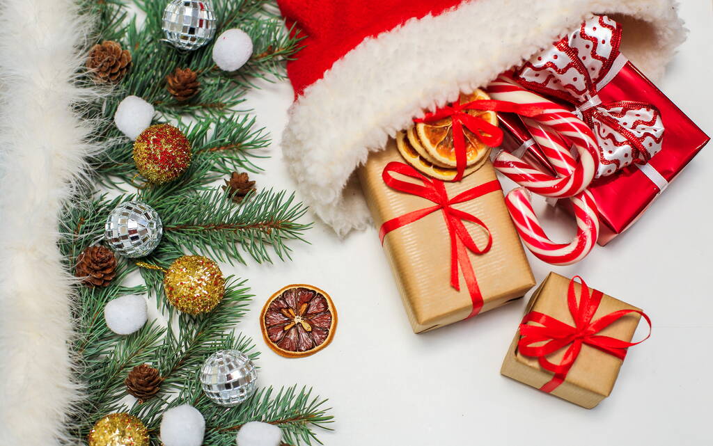 Composition de Noël de branches de sapin et jouets de Noël. Chapeau de Père Noël avec cadeaux, avec espace pour le texte, position horizontale sur un fond blanc - Photo, image