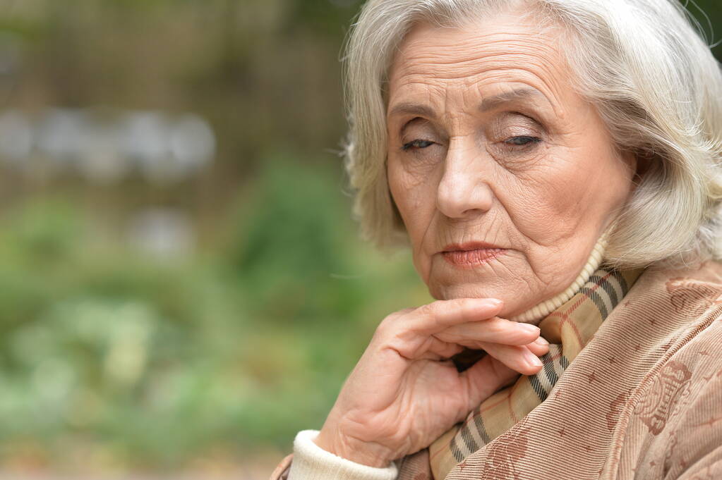 smutna, troskliwa starsza kobieta w parku - Zdjęcie, obraz