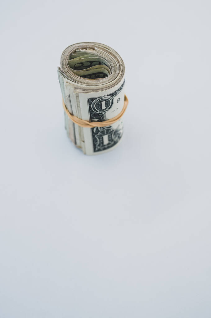 垂直方向のトップビューは、薄い青の背景に孤立したロールアメリカの銀行券の束を撮影しました。 - 写真・画像