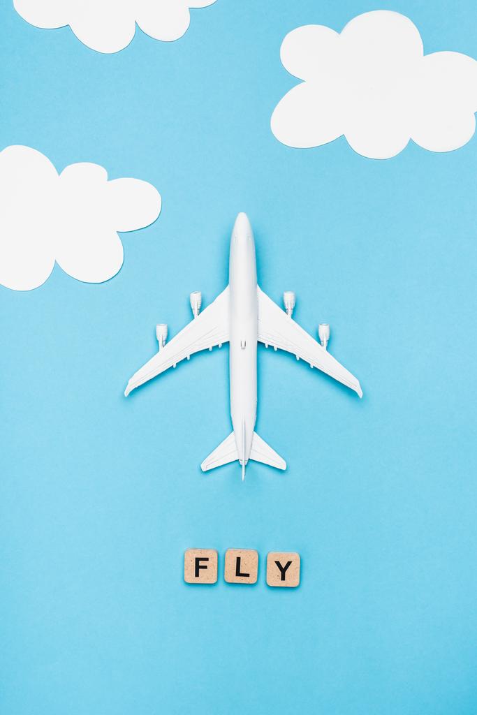 Mavi gökyüzü arka planında kelime sineği olan uçak modelinin ve küplerin üst görünümü - Fotoğraf, Görsel