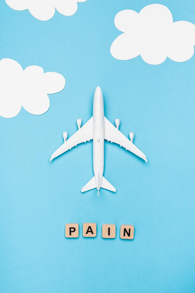 top view of plane model and cubes with word pain on blue sky background - Photo, Image