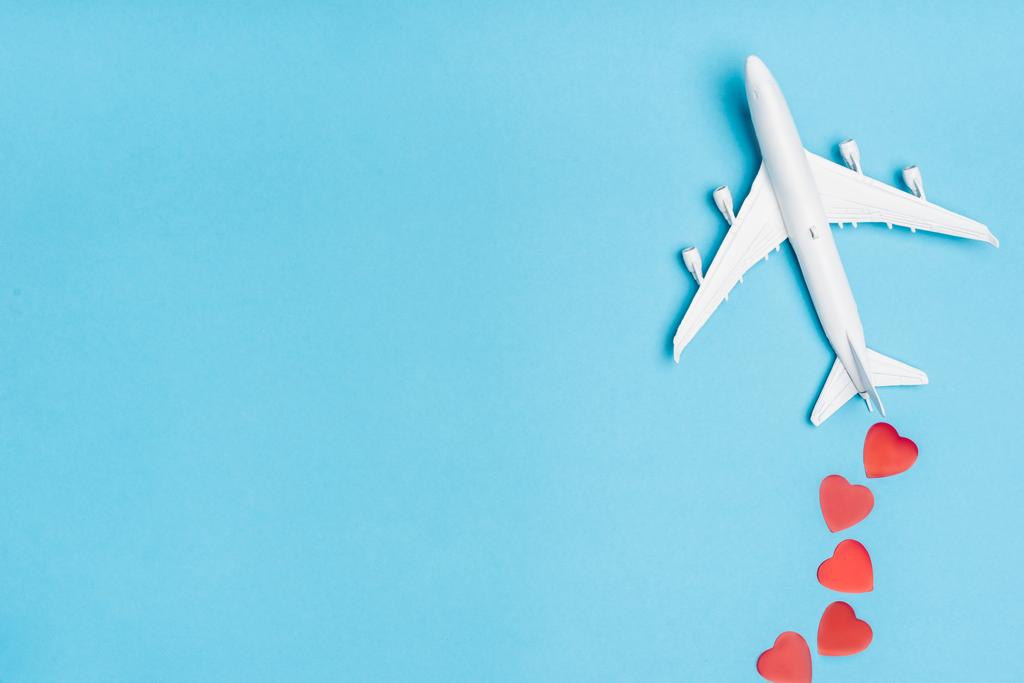 вид сверху на модель самолета и красные сердечки на синем фоне - Фото, изображение
