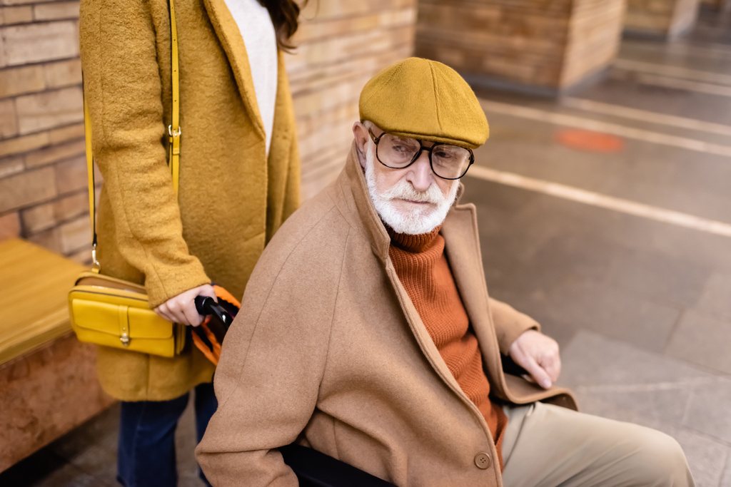 nő gazdaság kerekesszék idős fogyatékkal élő férfi underground platform - Fotó, kép