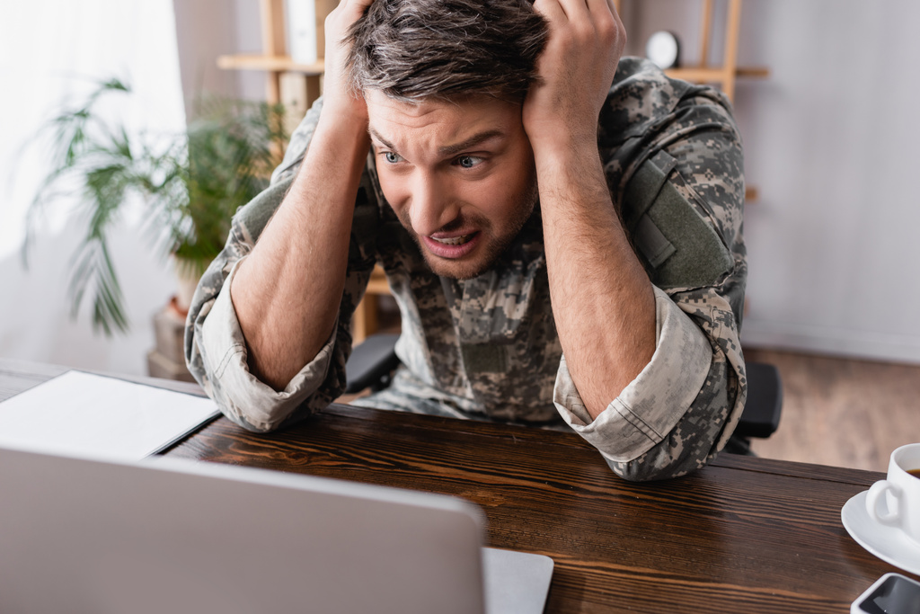homem militar estressado olhando para laptop no escritório - Foto, Imagem